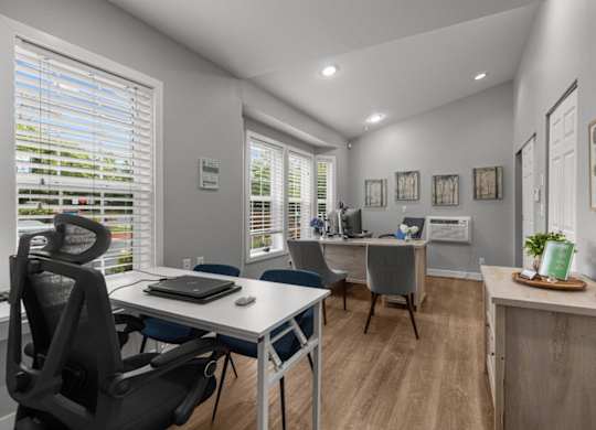 a home office with a desk and a chair and a window