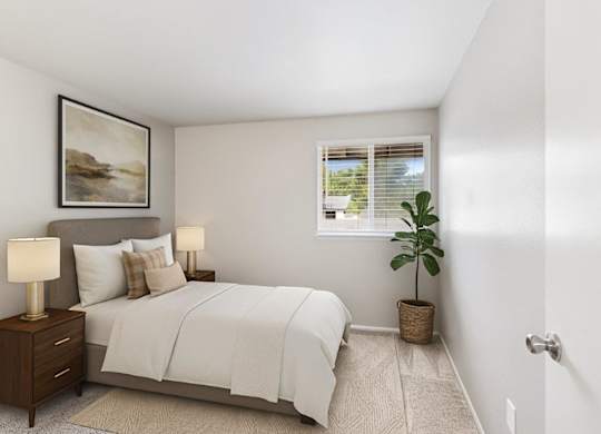 A bedroom with a bed, nightstands, and a plant.