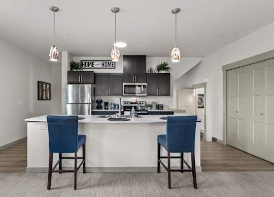 A kitchen with a white counter and blue chairs.