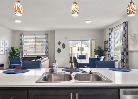 A modern kitchen with a large island and a view of the living room.