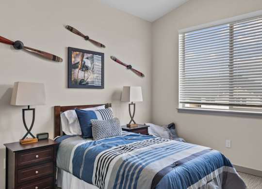 A bedroom with a bed, two lamps, and a picture on the wall.