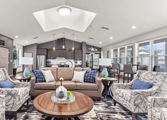A living room with a brown sofa, two armchairs, and a coffee table.