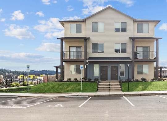 A two-story building with a parking lot in front.