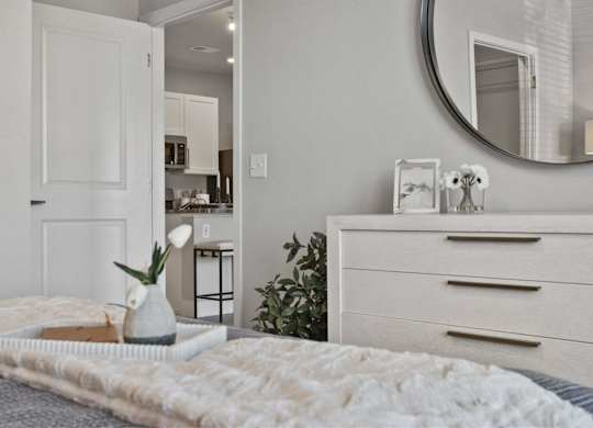 A bedroom with a bed, dresser, and mirror.