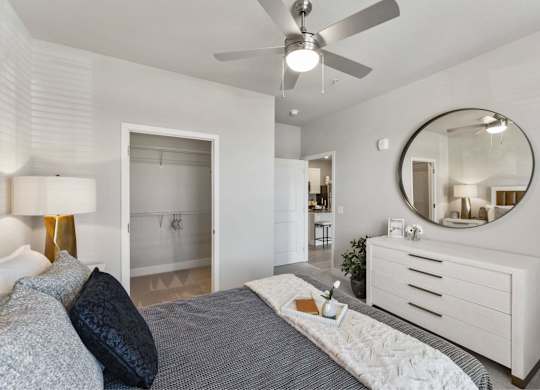 A bedroom with a bed, dresser, and mirror.