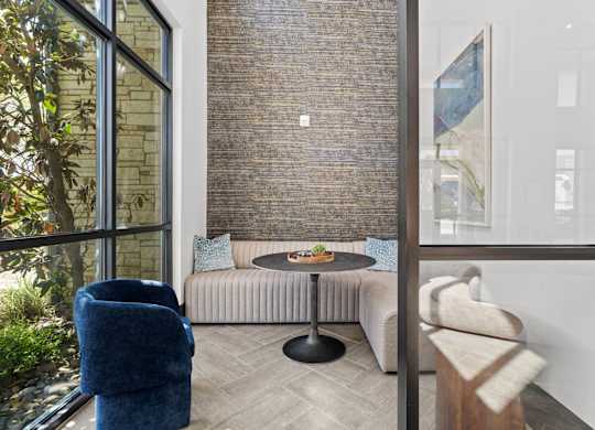 A living room with a blue chair and a round table.