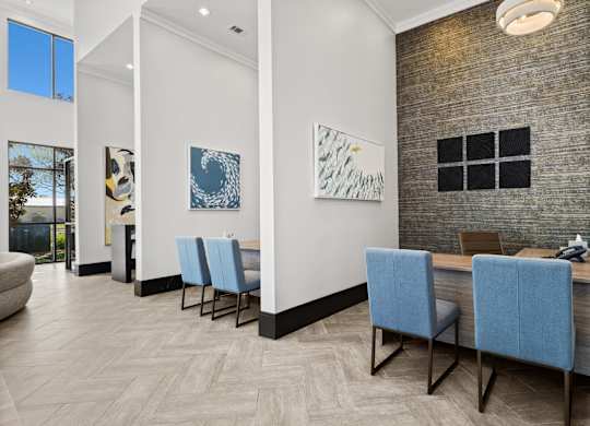 A room with a long table and blue chairs.