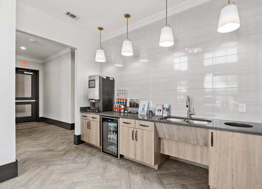 A kitchen with a refrigerator, sink, and cabinets.