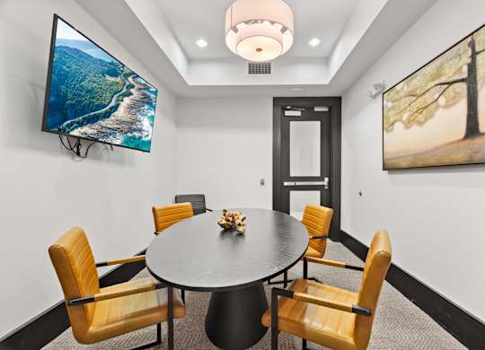 A conference room with a large table and chairs.