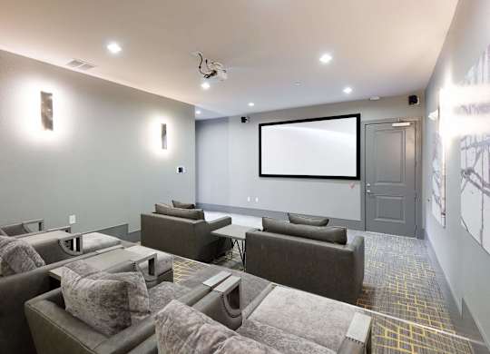 A modern home theater with a large screen and comfortable seating.