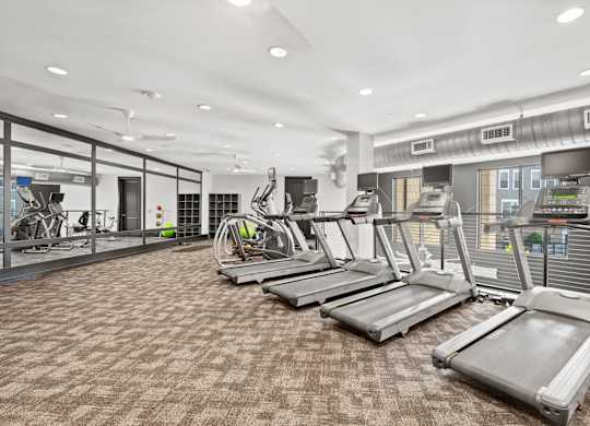A gym with treadmills and other exercise equipment.