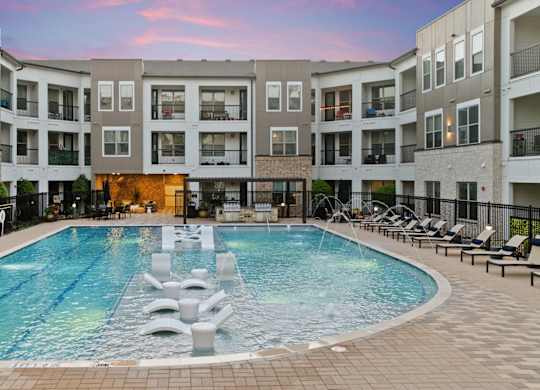 A large swimming pool in the middle of a courtyard surrounded by apartment buildings.
