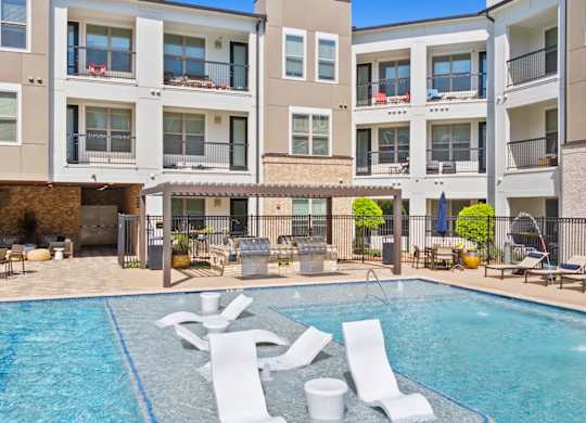 A swimming pool in front of apartment buildings.