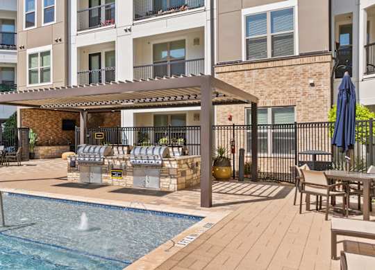 A pool area with a hot tub and a building in the background.