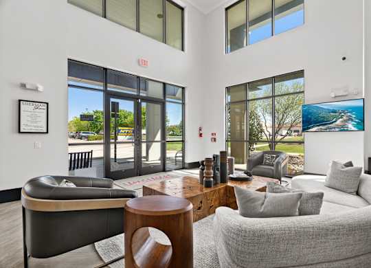 A living room with a grey couch and a black leather chair.