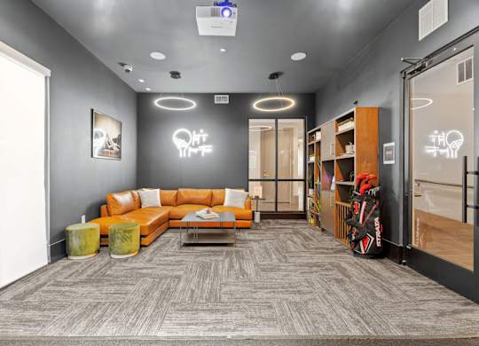 A modern office space with a grey carpet and a grey wall with a white light bulb decoration.