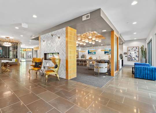 A spacious lobby with a variety of seating options and a large chandelier.