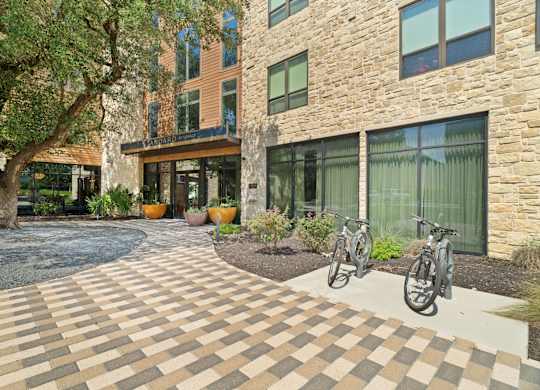 A courtyard with a brick patterned floor and a bicycle.