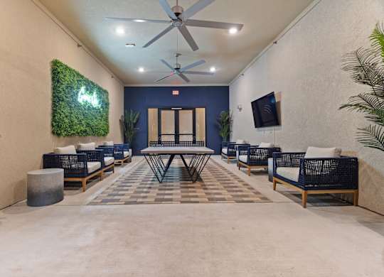 A room with a green wall hanging and a ceiling fan.