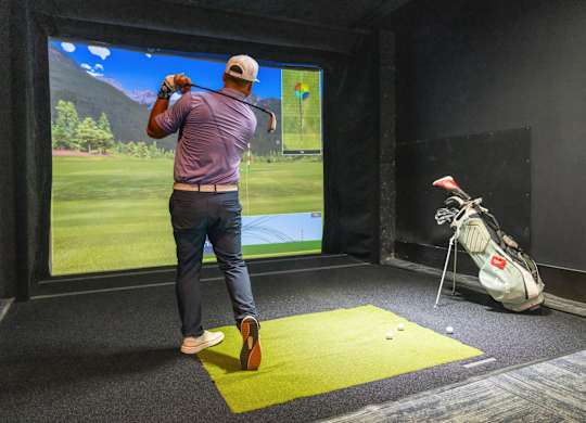 A man is playing golf in a virtual reality game.