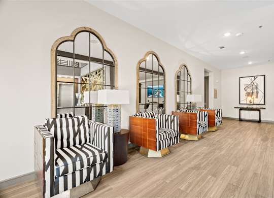 A room with striped chairs and wooden floors.