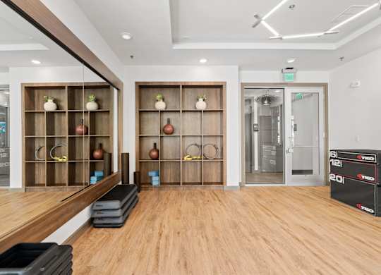 A gym with wooden floors and a variety of exercise equipment.