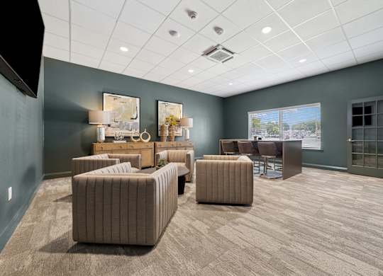 A spacious room with a grey carpet and brown furniture.