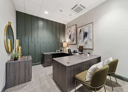 A modern office with a green wall and a wooden desk.