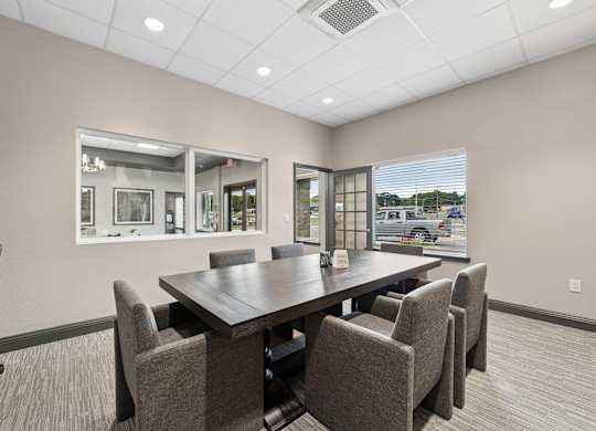 A conference room with a large table and chairs.