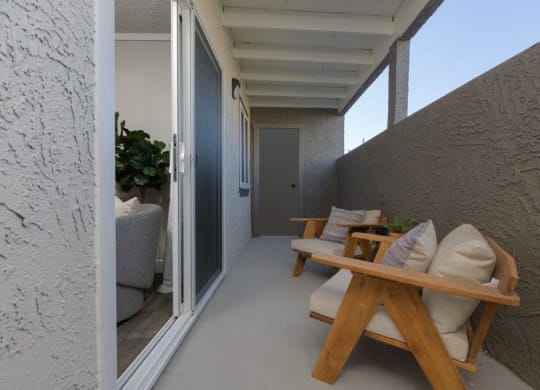 a porch with a wooden table and chairs on it