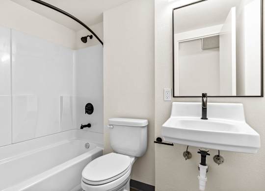 A white toilet sits next to a white sink in a bathroom.