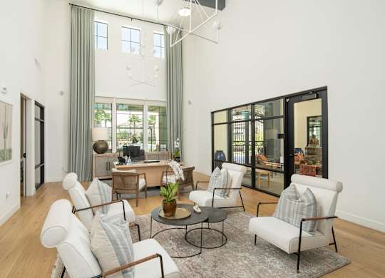 A living room with a white couch and a glass table.