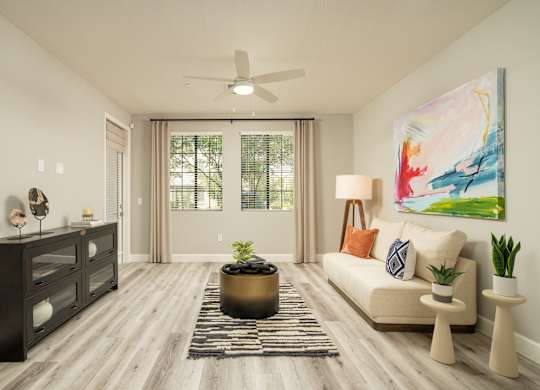 A living room with a large painting on the wall and a couch with pillows.