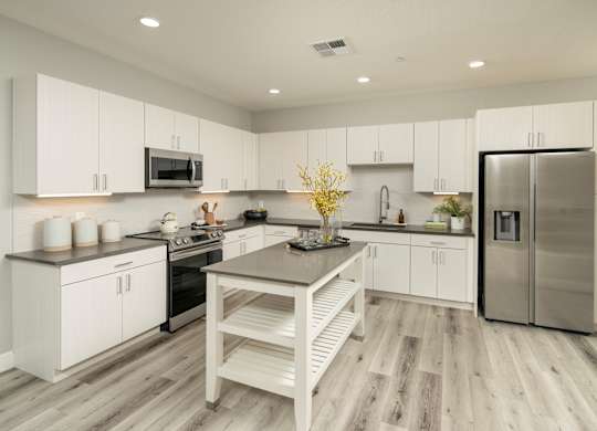 A modern kitchen with white cabinets and a wooden island.