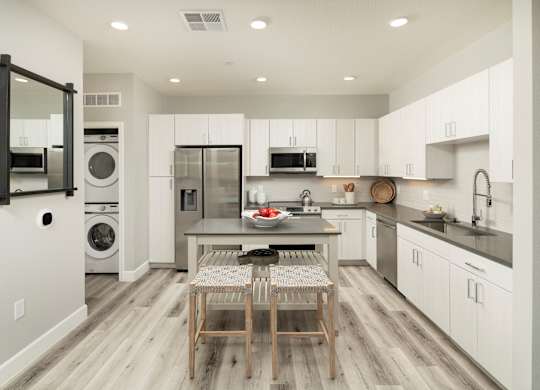 A modern kitchen with a dining table and chairs.