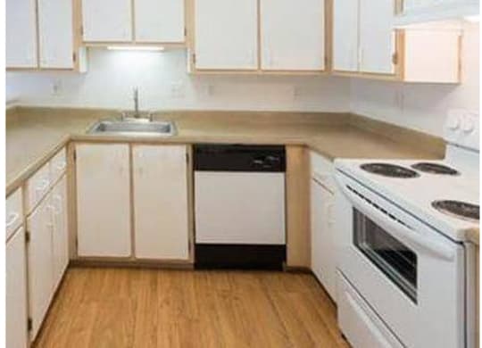 A kitchen with white appliances and wooden cabinets.