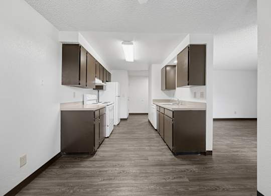 A kitchen with brown cabinets and a white wall.