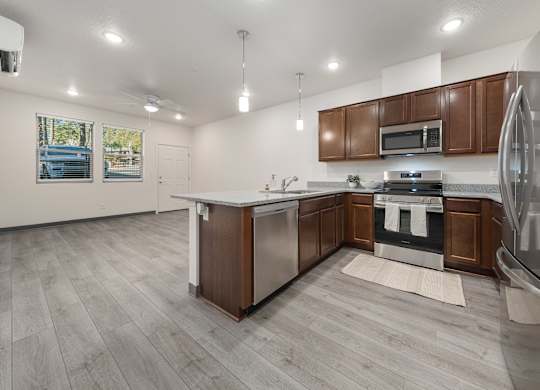 A modern kitchen with a white island and stainless steel appliances.