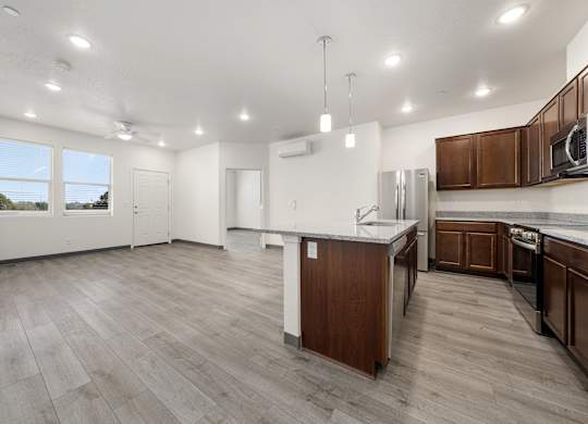 A spacious kitchen with wooden cabinets and a white countertop.