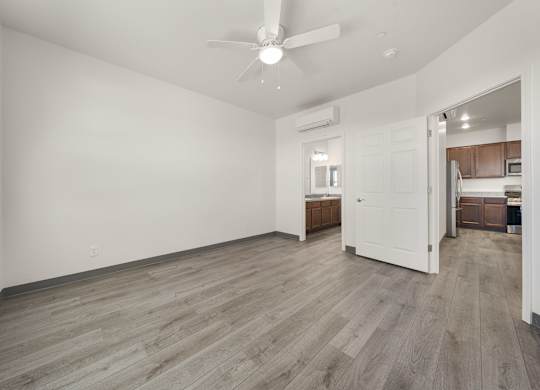 A room with a ceiling fan and wooden flooring.