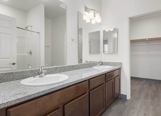 A bathroom with a sink, mirror, and wooden cabinets.