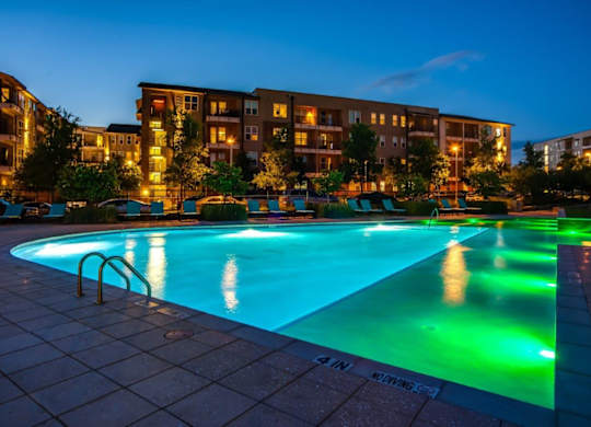A swimming pool in a residential area at dusk.
