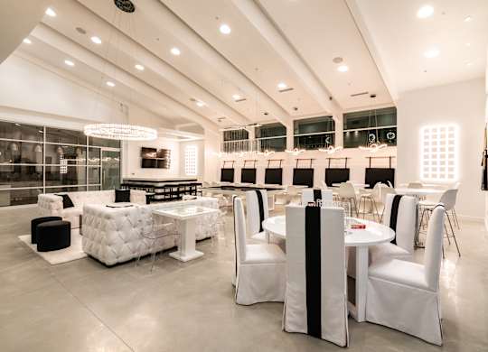 A white and black furniture store with a lot of white chairs and tables.