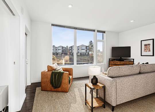 A living room with a couch, a chair, and a television.
