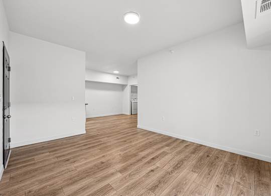 A room with wooden flooring and white walls.