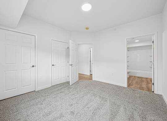 A room with white walls and a grey carpet.