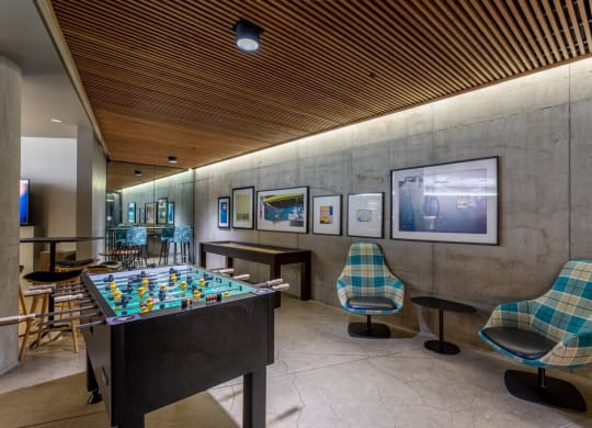 a game room with a foosball table and chairs