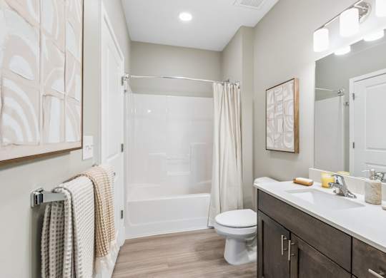 A bathroom with a toilet, sink, and shower.