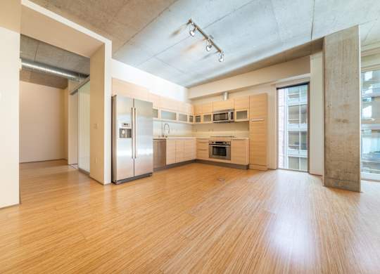 A kitchen with wooden floors and stainless steel appliances.