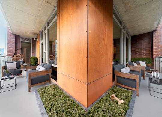 A modern balcony with a wooden floor and furniture.